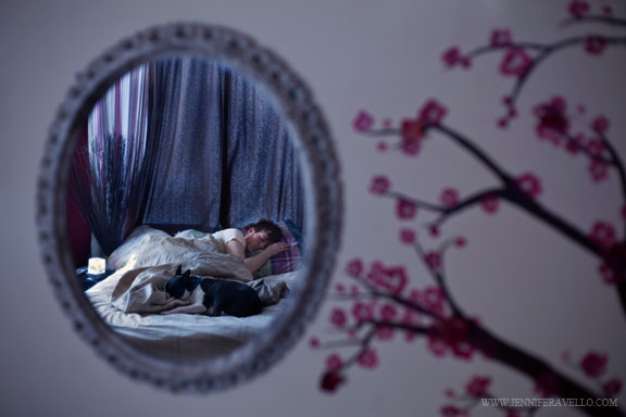 A boy and his dog asleep in bed